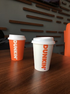 Three coffee cups sitting on top of a wooden table