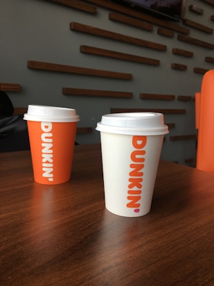 Three coffee cups sitting on top of a wooden table