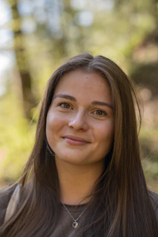 A woman with long hair is smiling for the camera