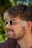 A man with sunglasses and a flower in his hair
