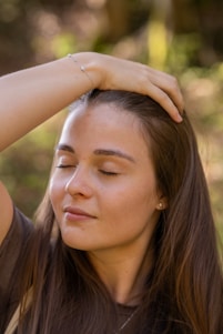 A woman is holding her head, breathing comfortably with calm and peacer hands