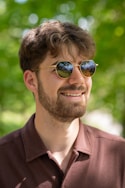 A man in a brown shirt and sunglasses