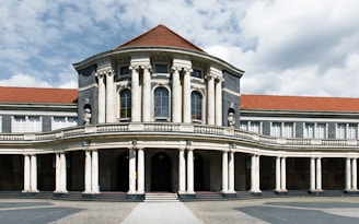 A large building with columns and a red roof