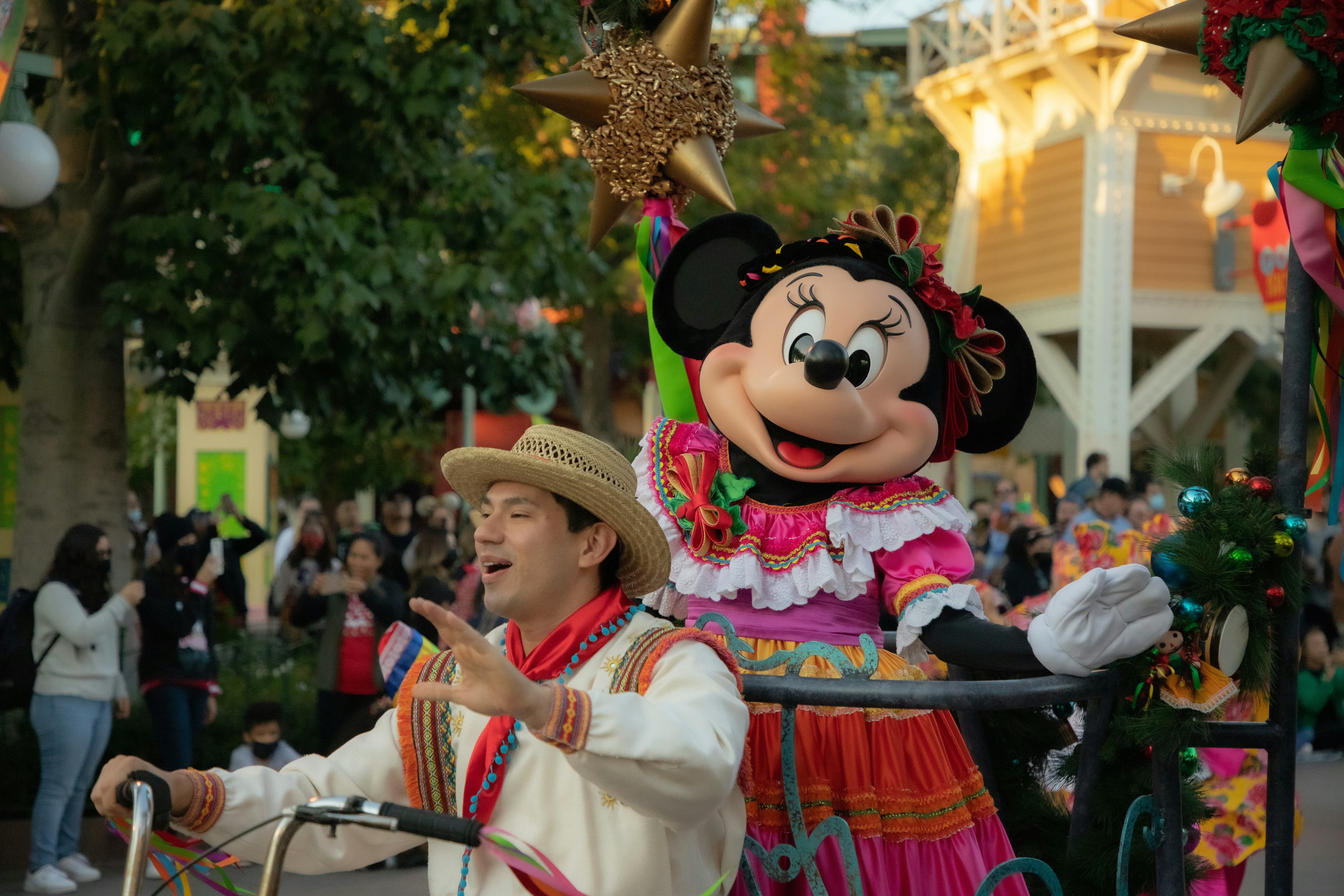 A man in a mickey mouse costume riding a cart