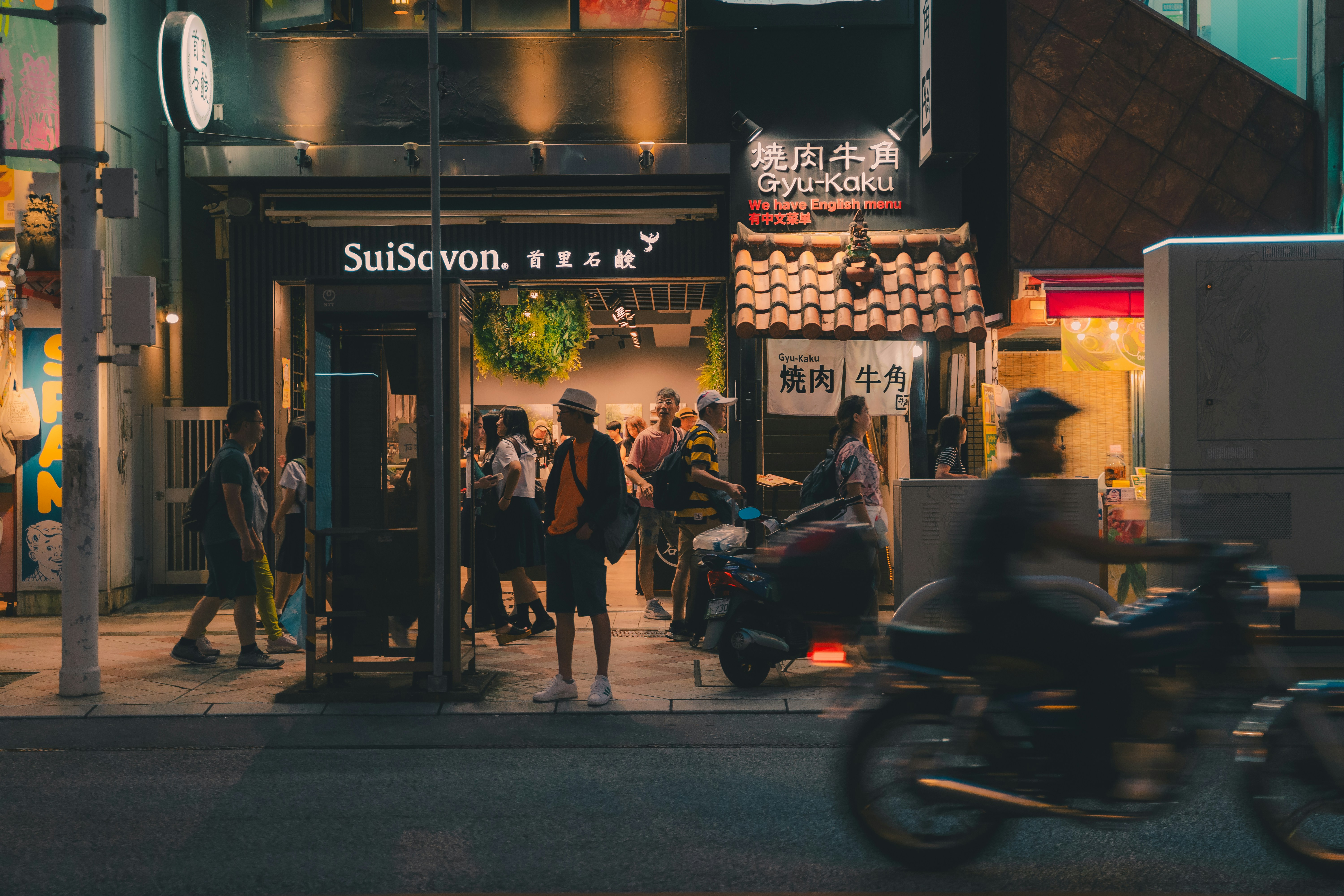 A man riding a motorcycle down a street next to a tall building