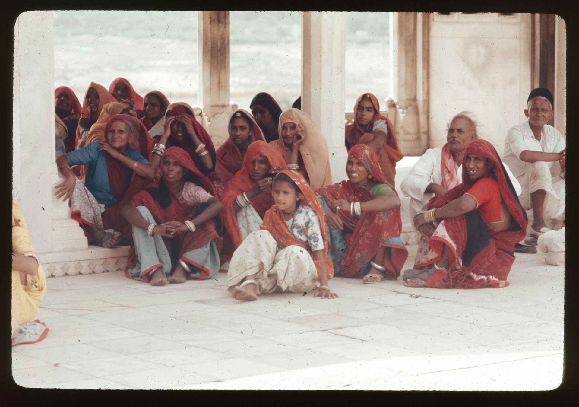 A group of people sitting and standing around each other