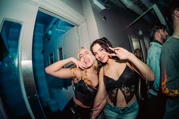 Two friends posing for the camera at a party