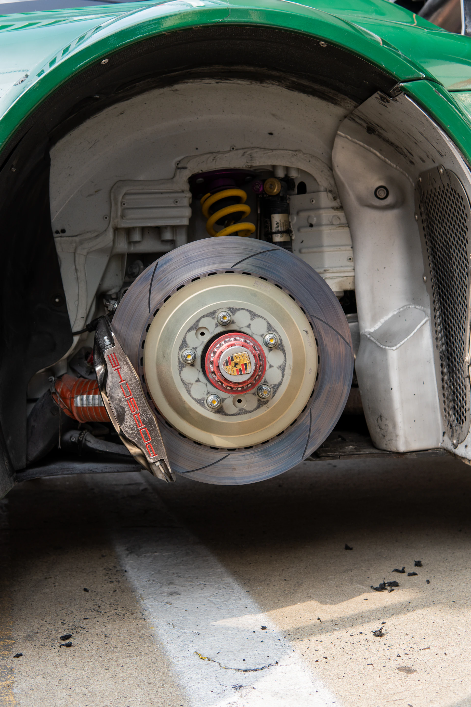 The front of a green car with a flat tire