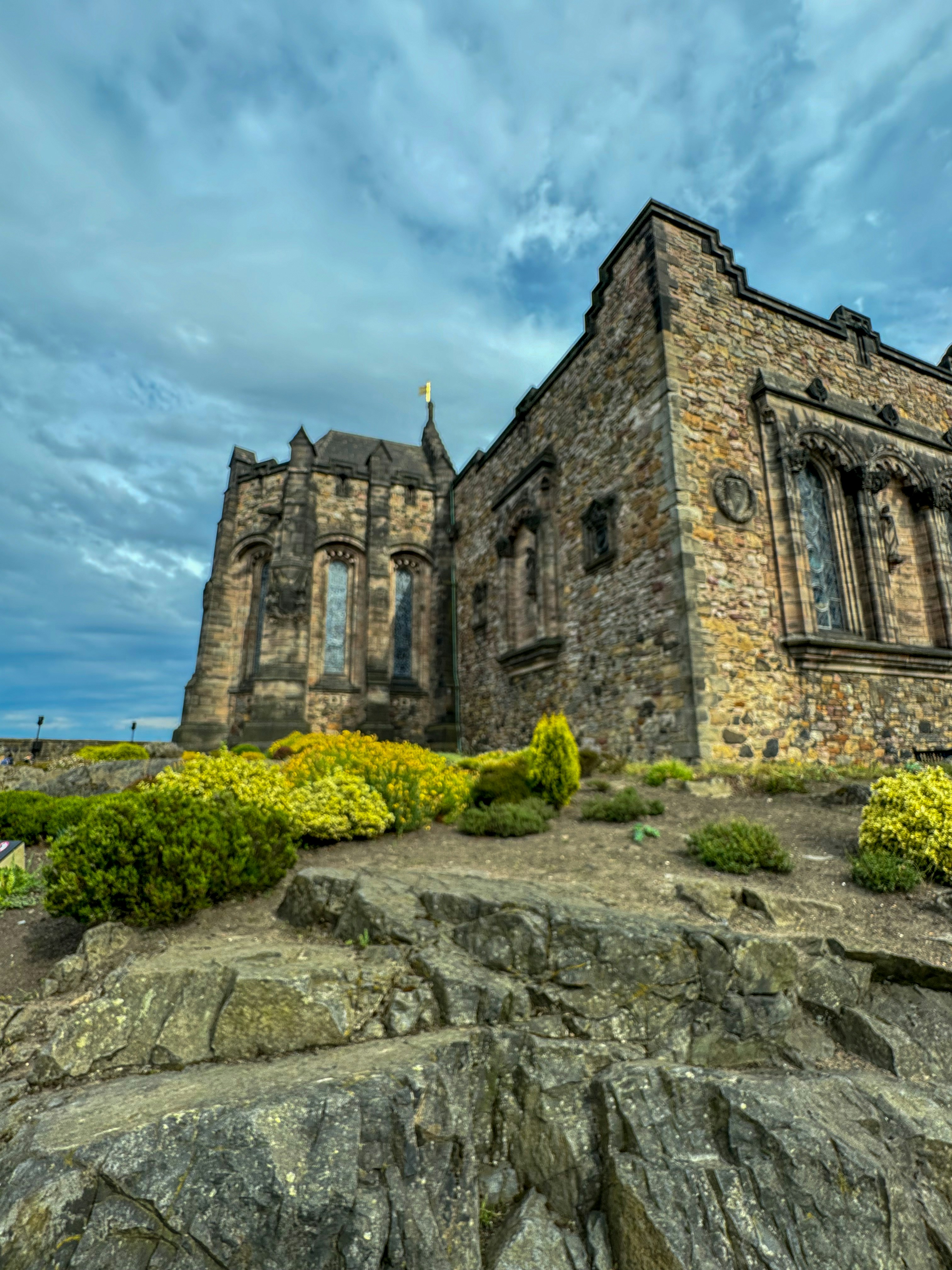 A large stone building sitting on top of a rocky hill