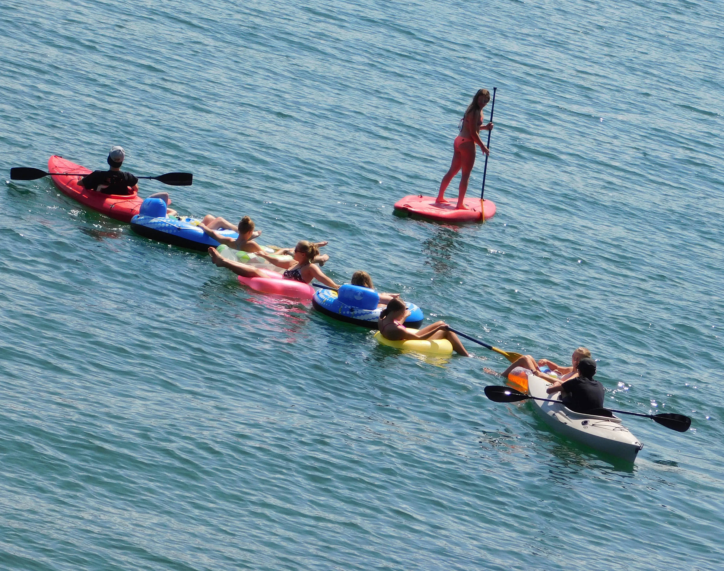 Kayakers and paddleboarders traveling across open water
