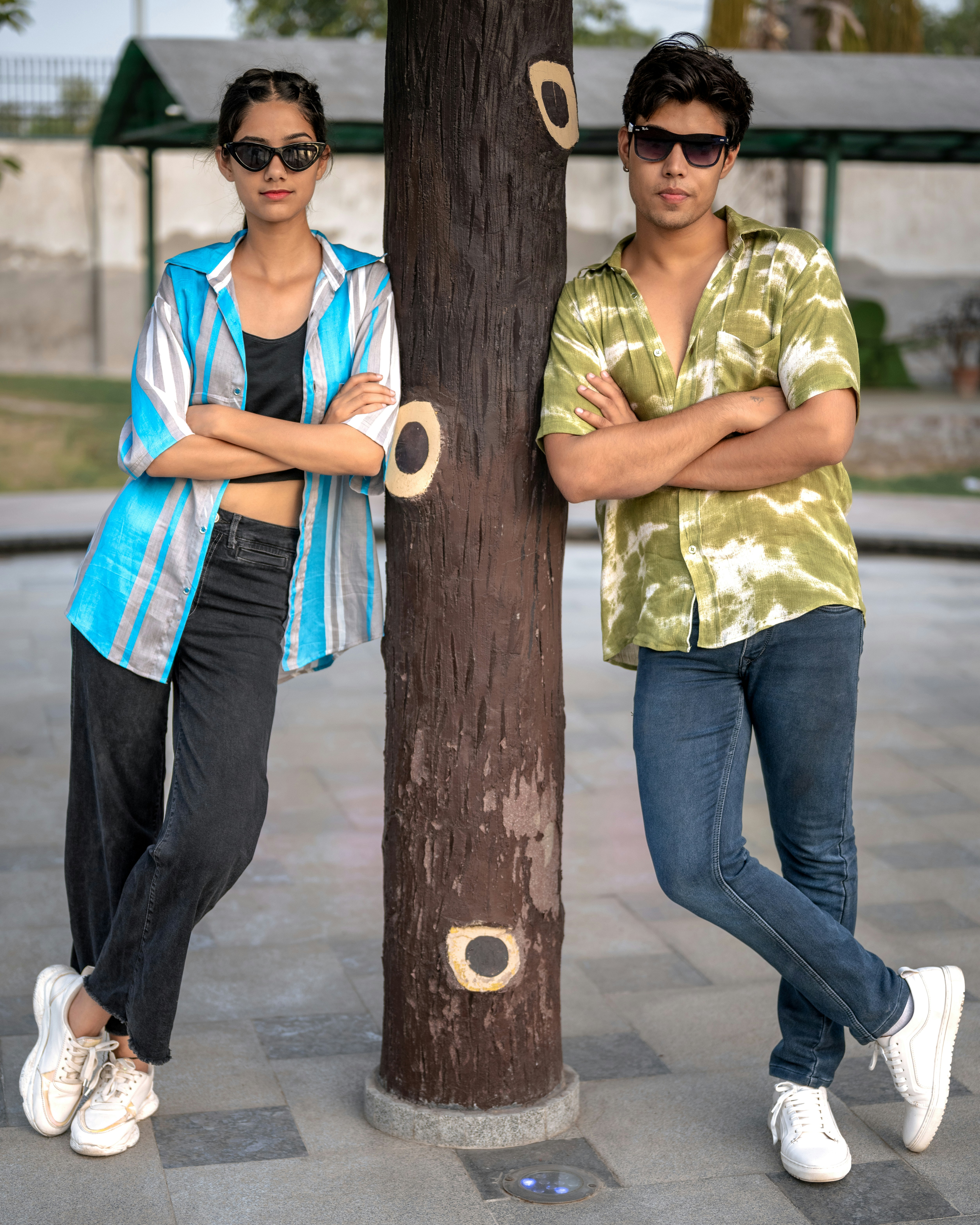A man and a woman standing next to a tree