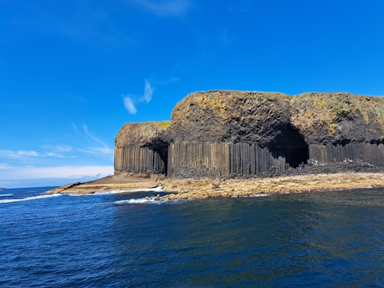 A large rock formation in the middle of a body of water