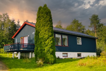 A blue house sitting on top of a lush green field