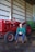 A man sitting on a hay bale next to a tractor