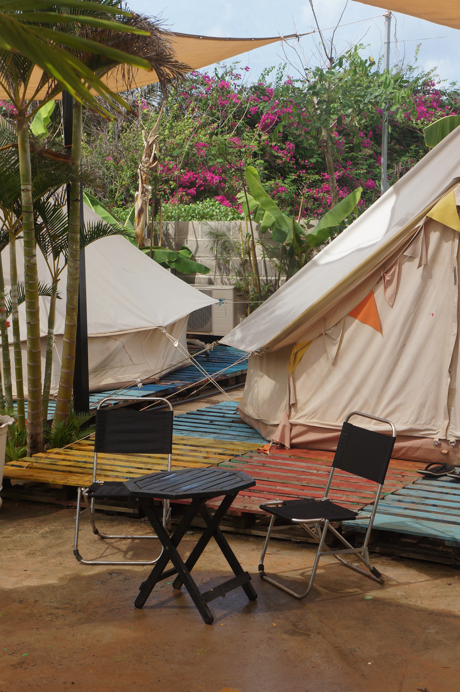Camping chairs and table arranged beneath an outdoor shelter
