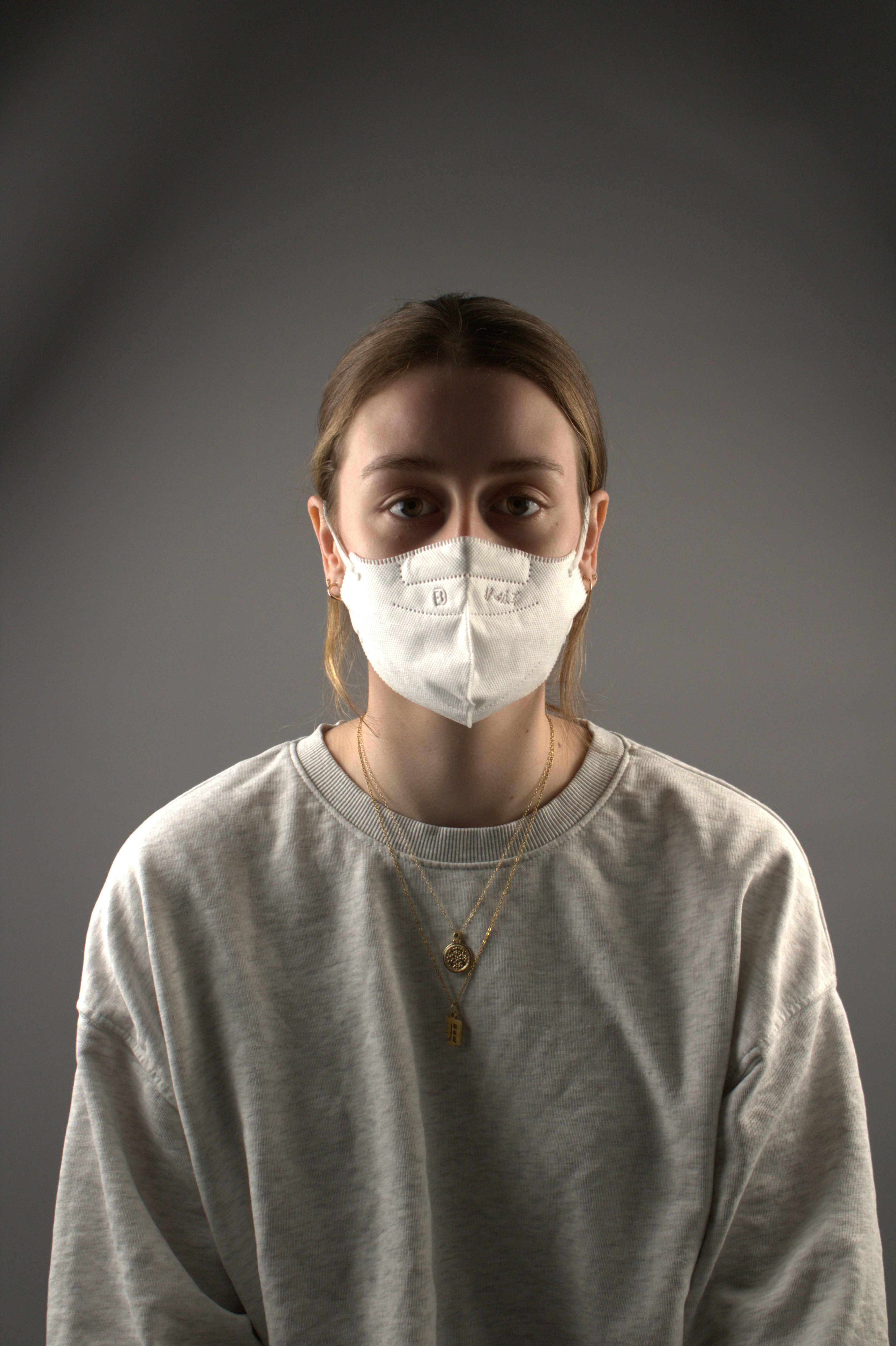 Eine Frau, die in einem dunklen Raum eine Gesichtsmaske trägt