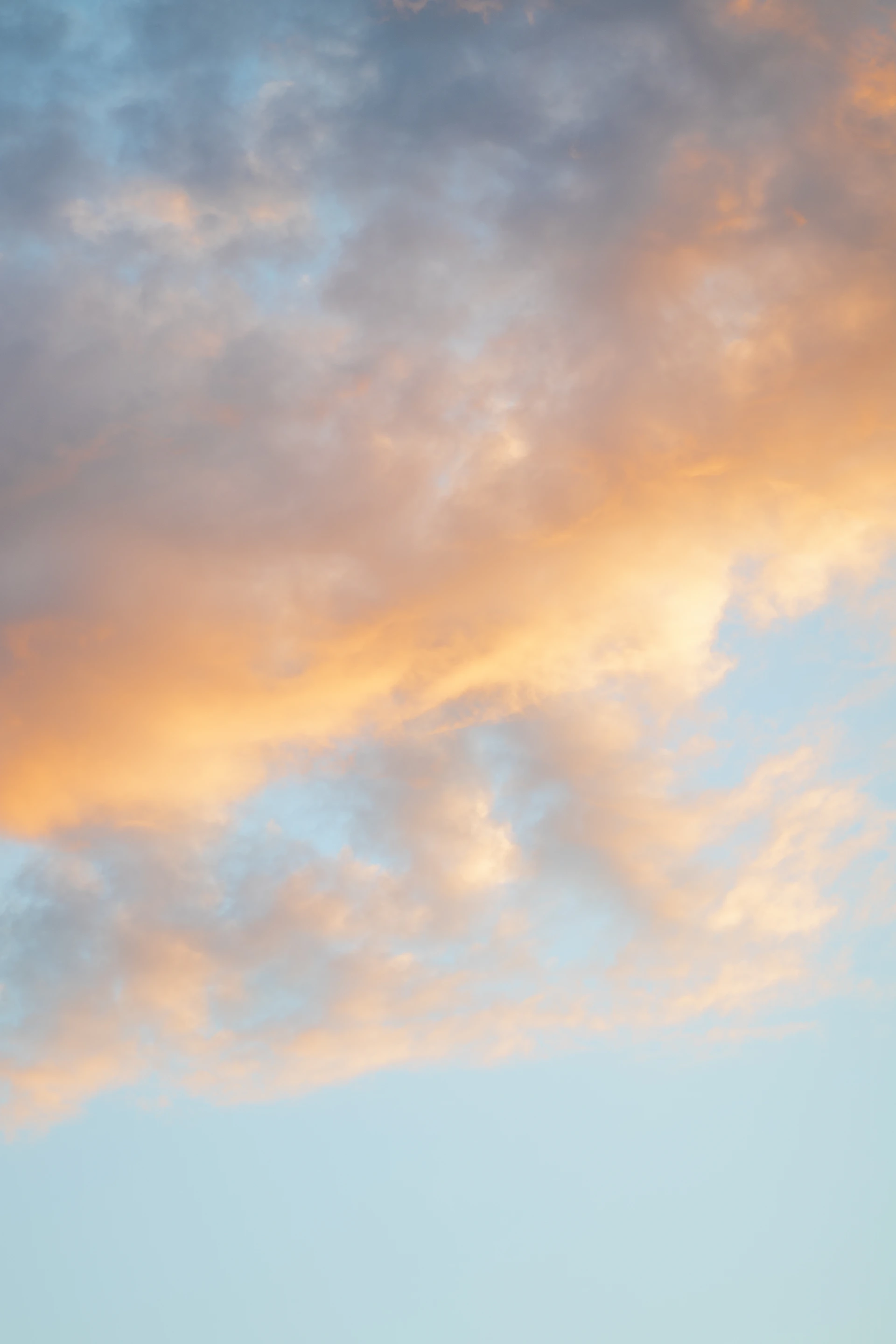 A plane flying in the sky at sunset