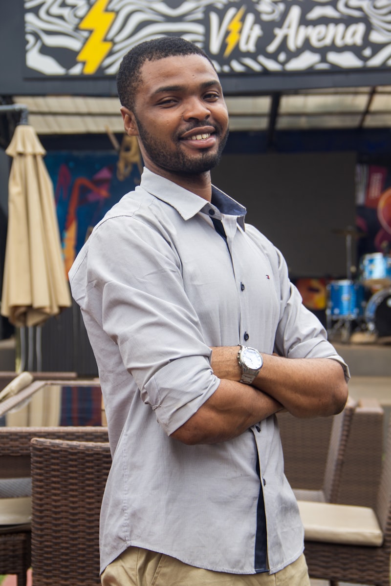 Shop owner standing with arms crossed in front of his storefront