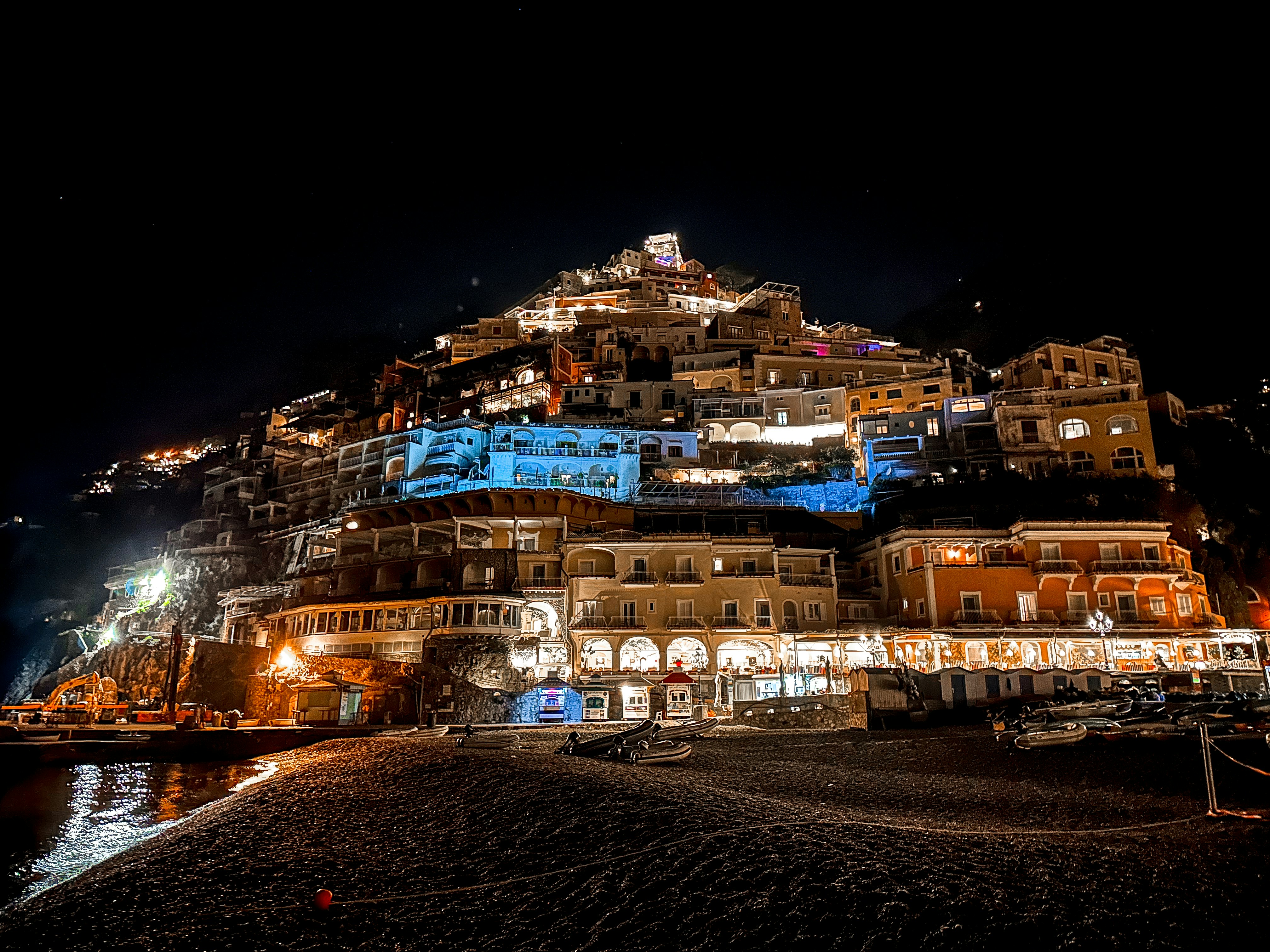 A night view of a city with a mountain in the background