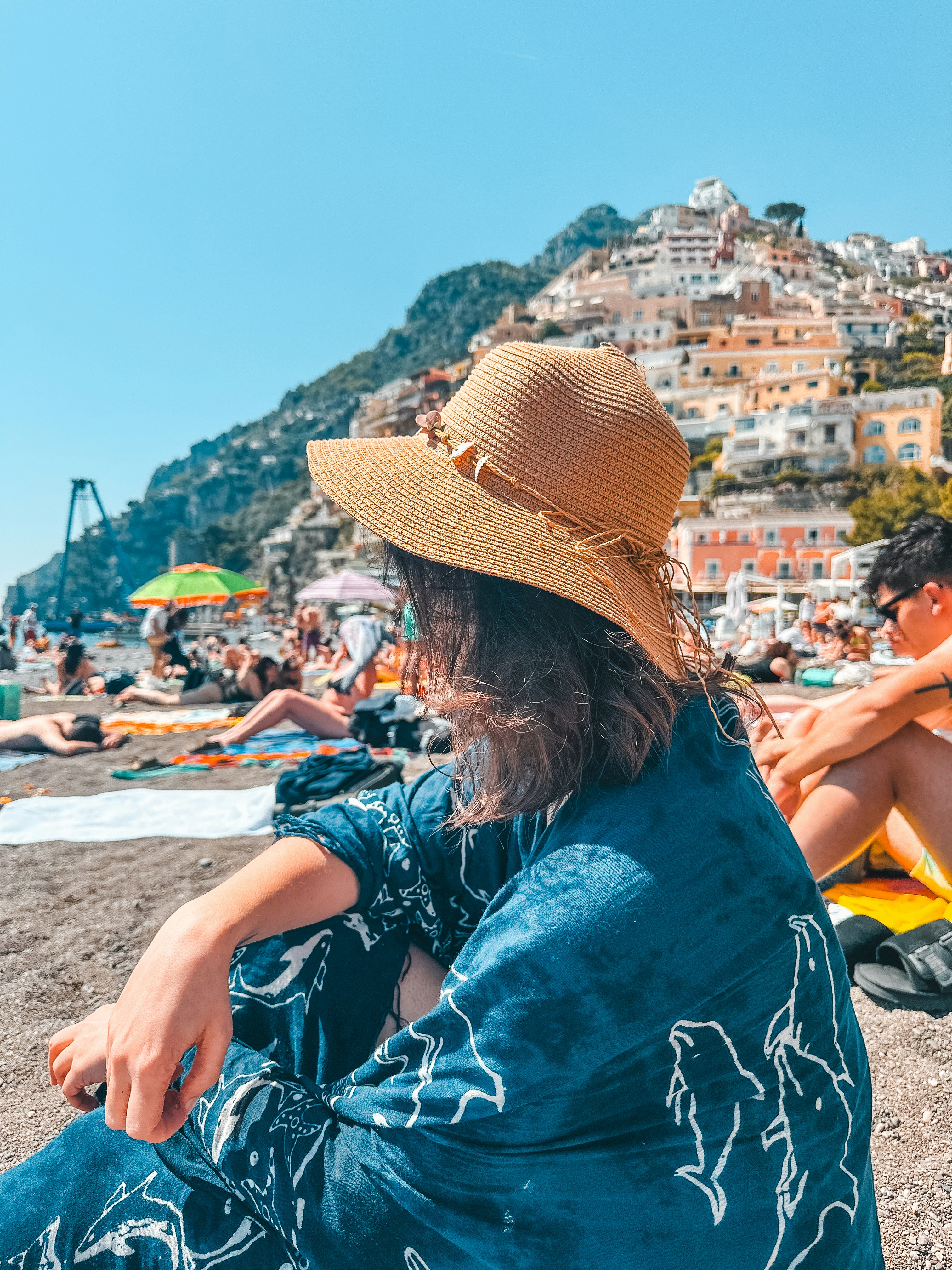 A woman sitting on a beach next to a man
