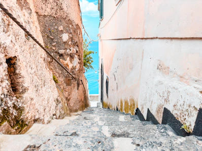 A narrow street with a stone wall next to it