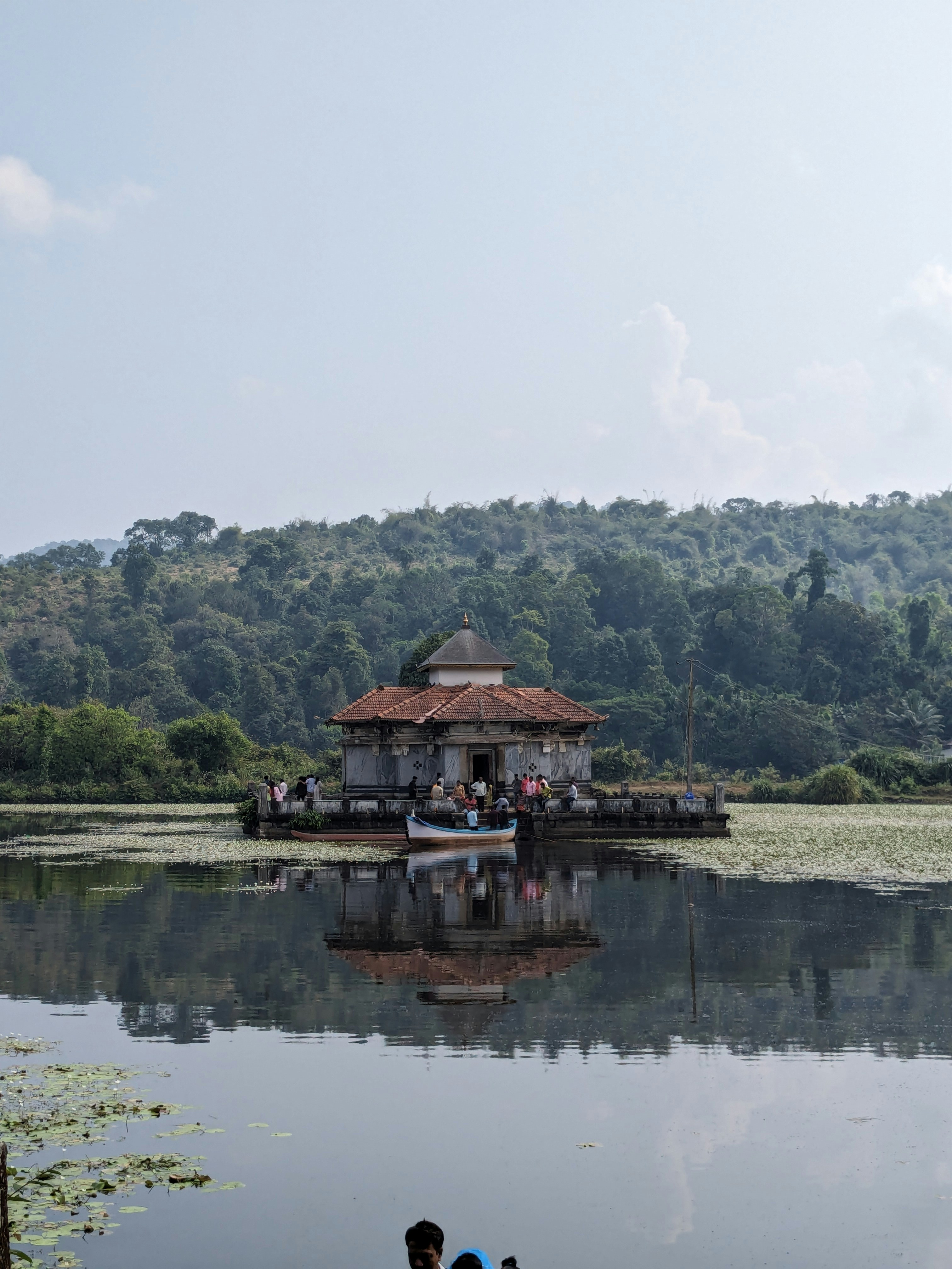 A couple of people sitting on a bench near a lake