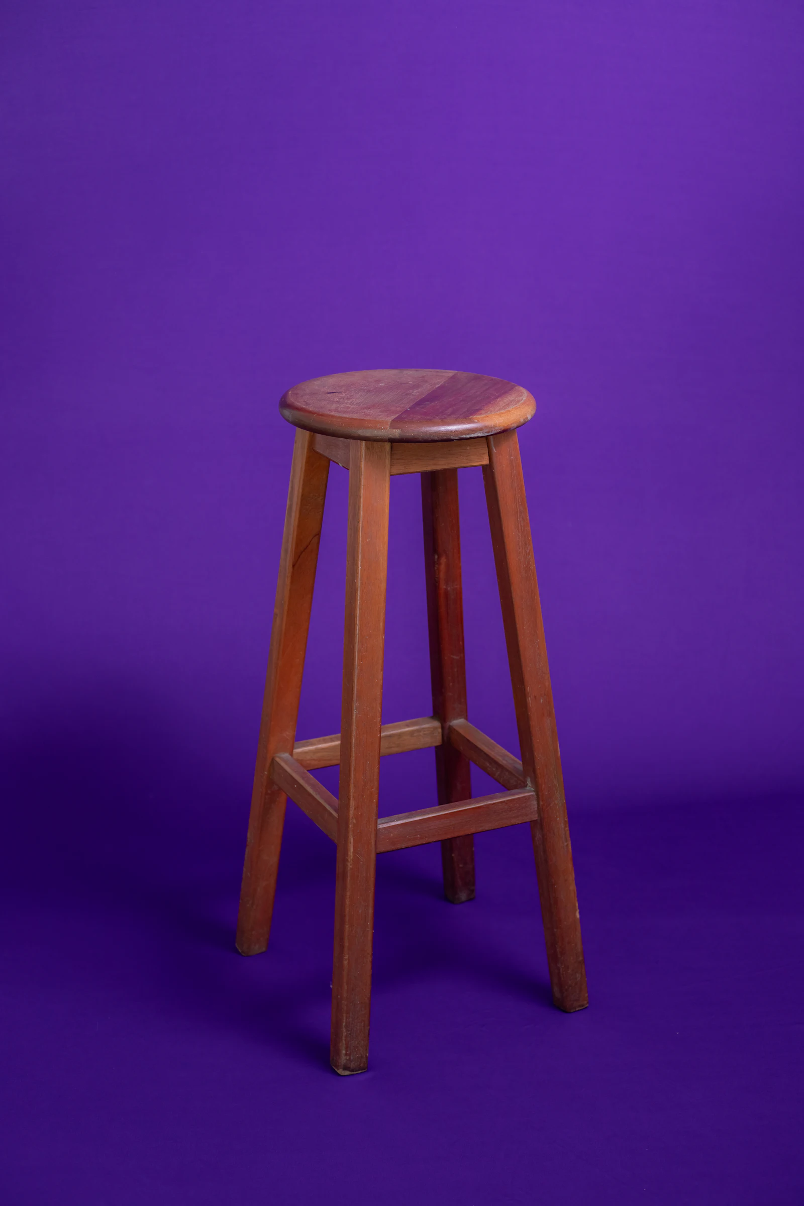 Un tabouret seul sur fond violet