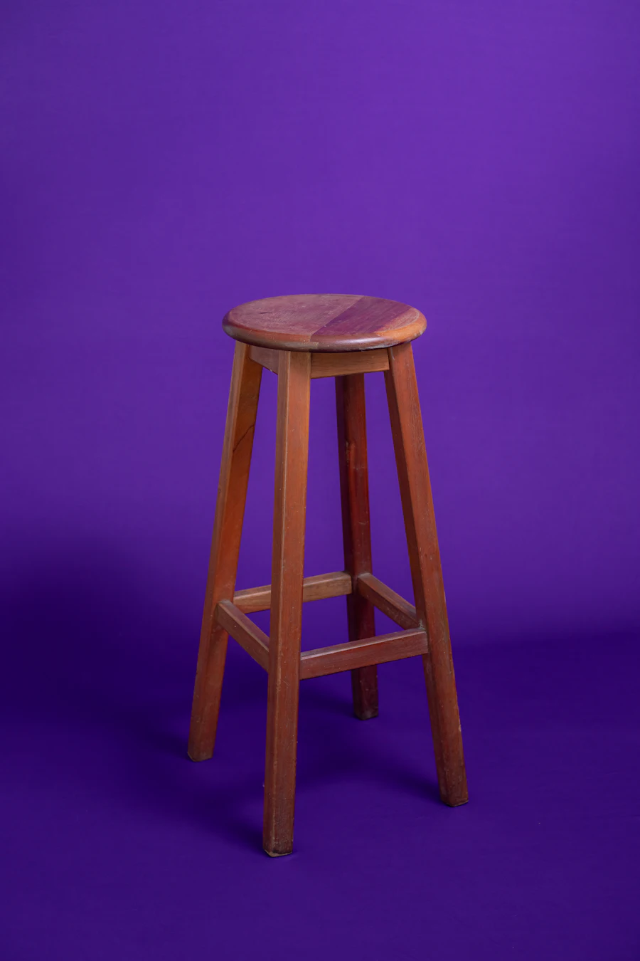 Un tabouret seul sur fond violet