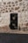 A black door on the side of a stone building