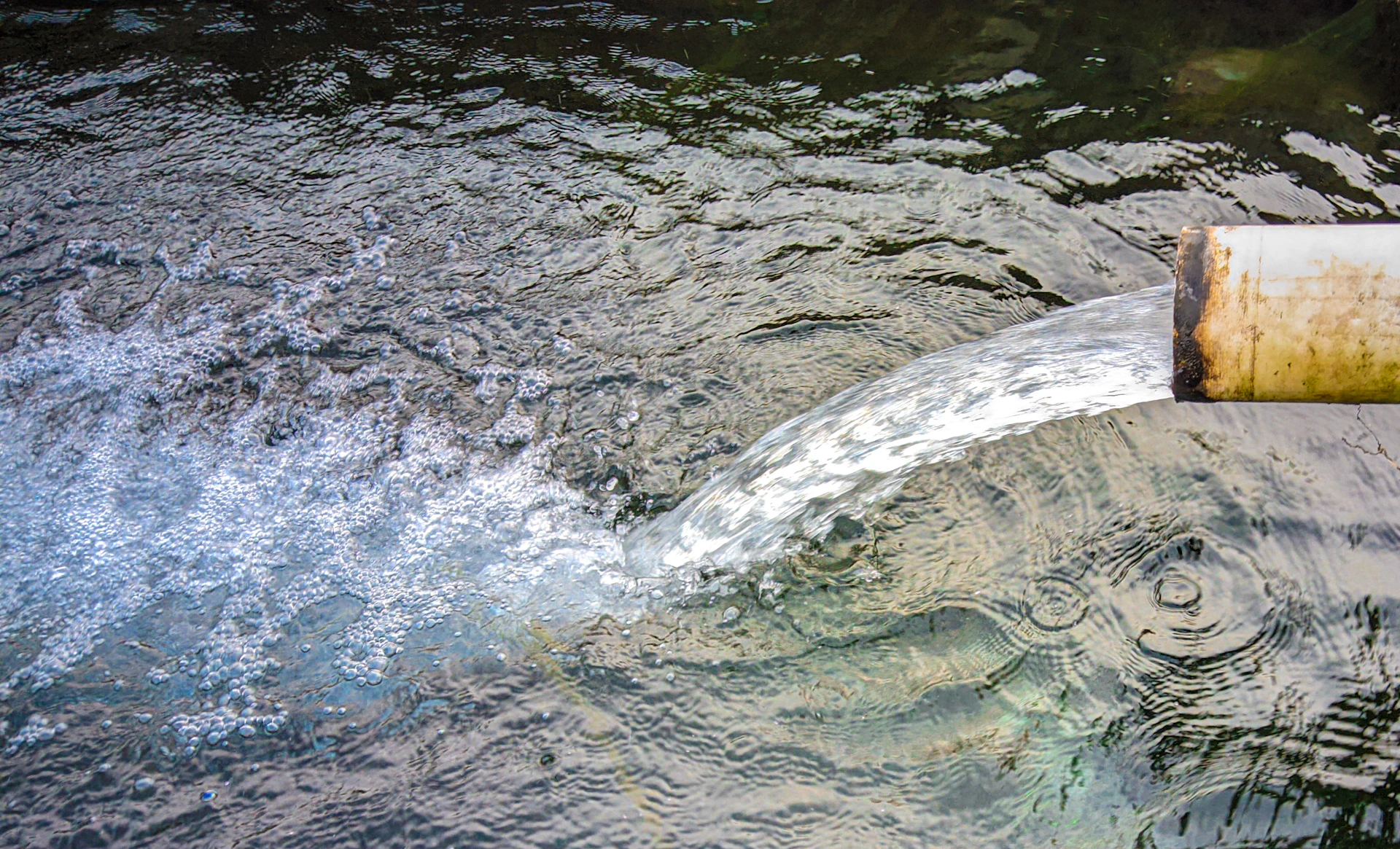 A pipe sticking out of a body of water