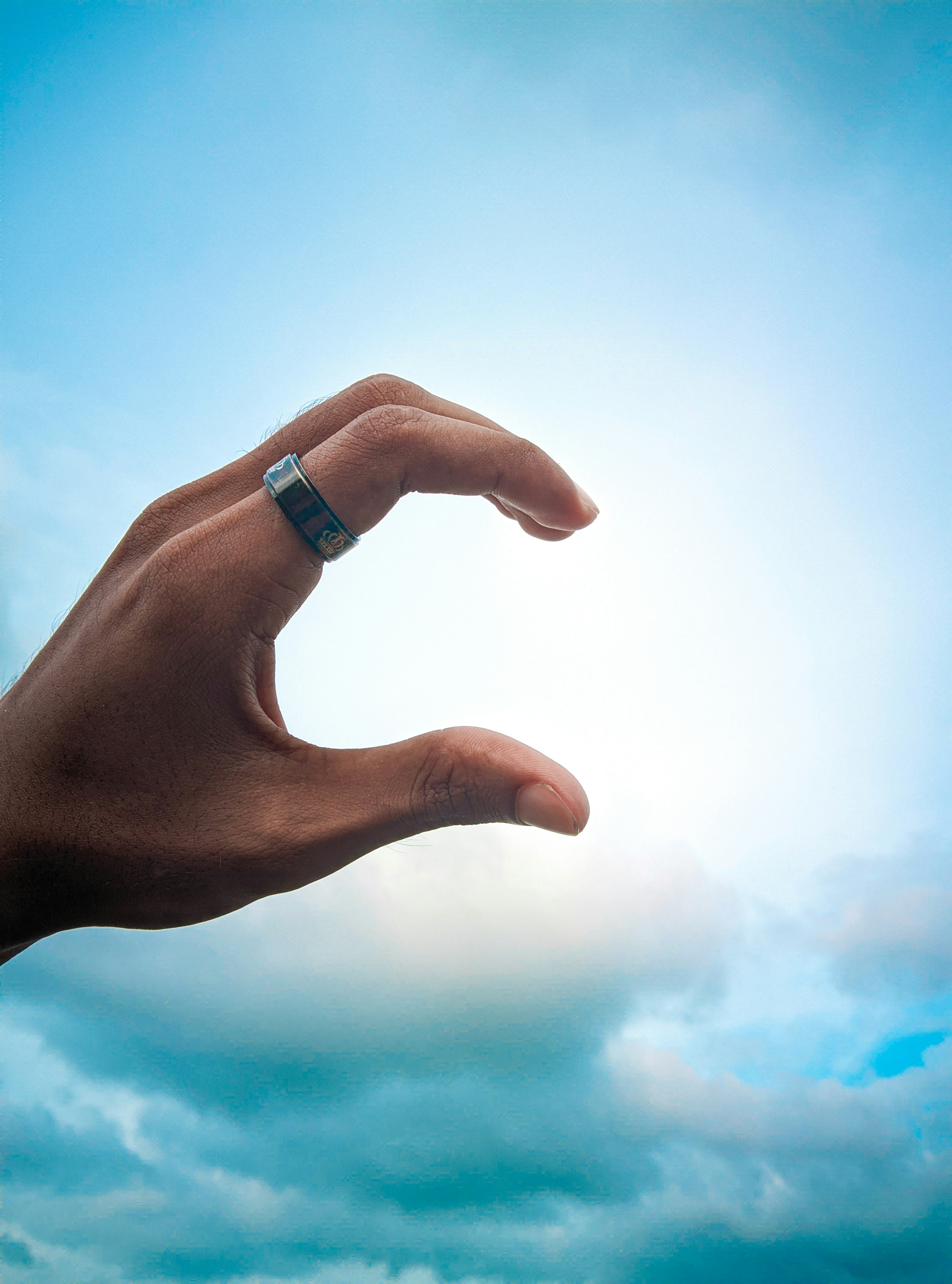 A person's hand reaching up into the sky