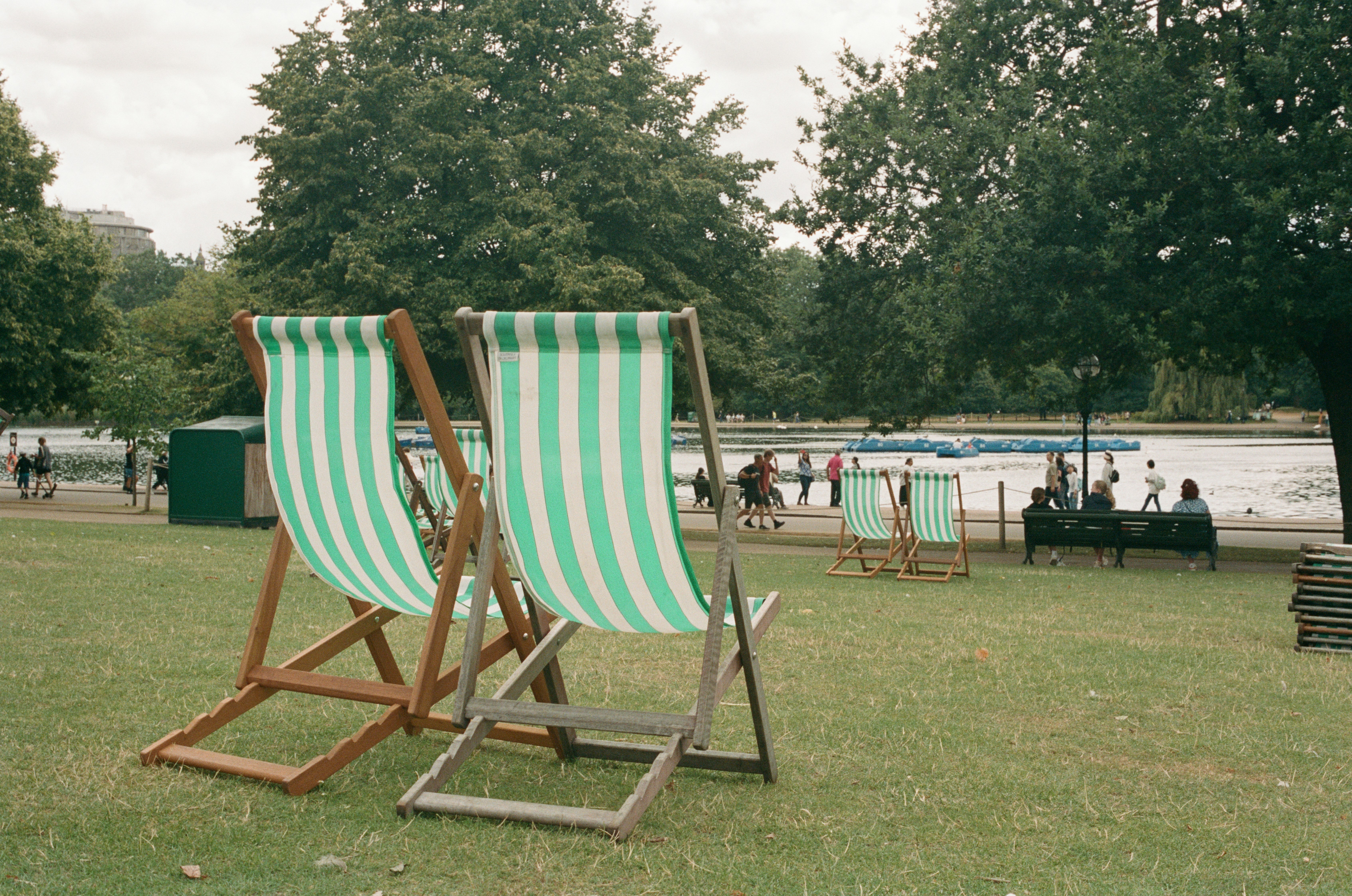 A couple of lawn chairs sitting on top of a lush green field