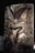 A wooden carving of a face with green eyes