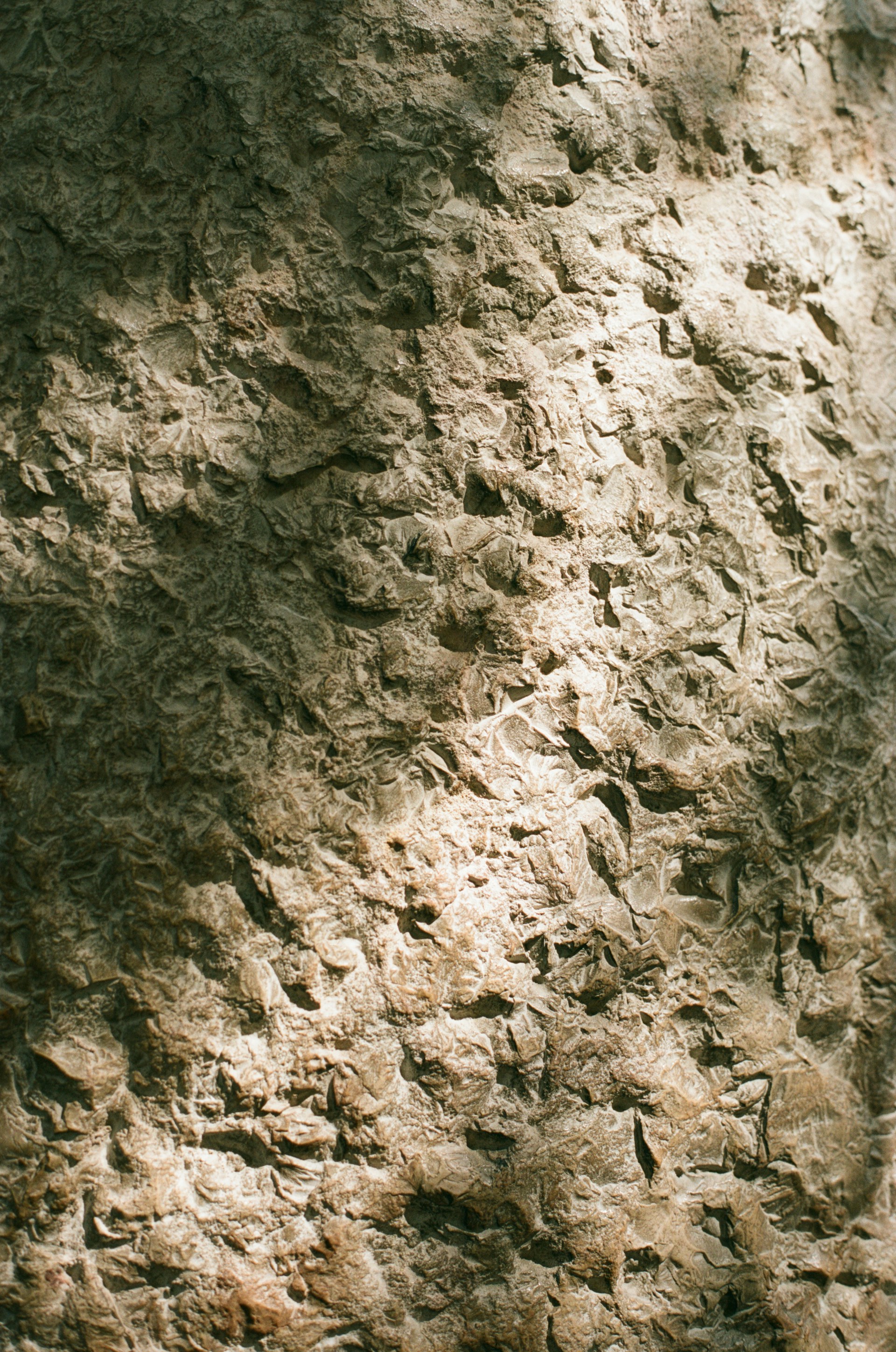 A close up of a stone wall with a clock on it