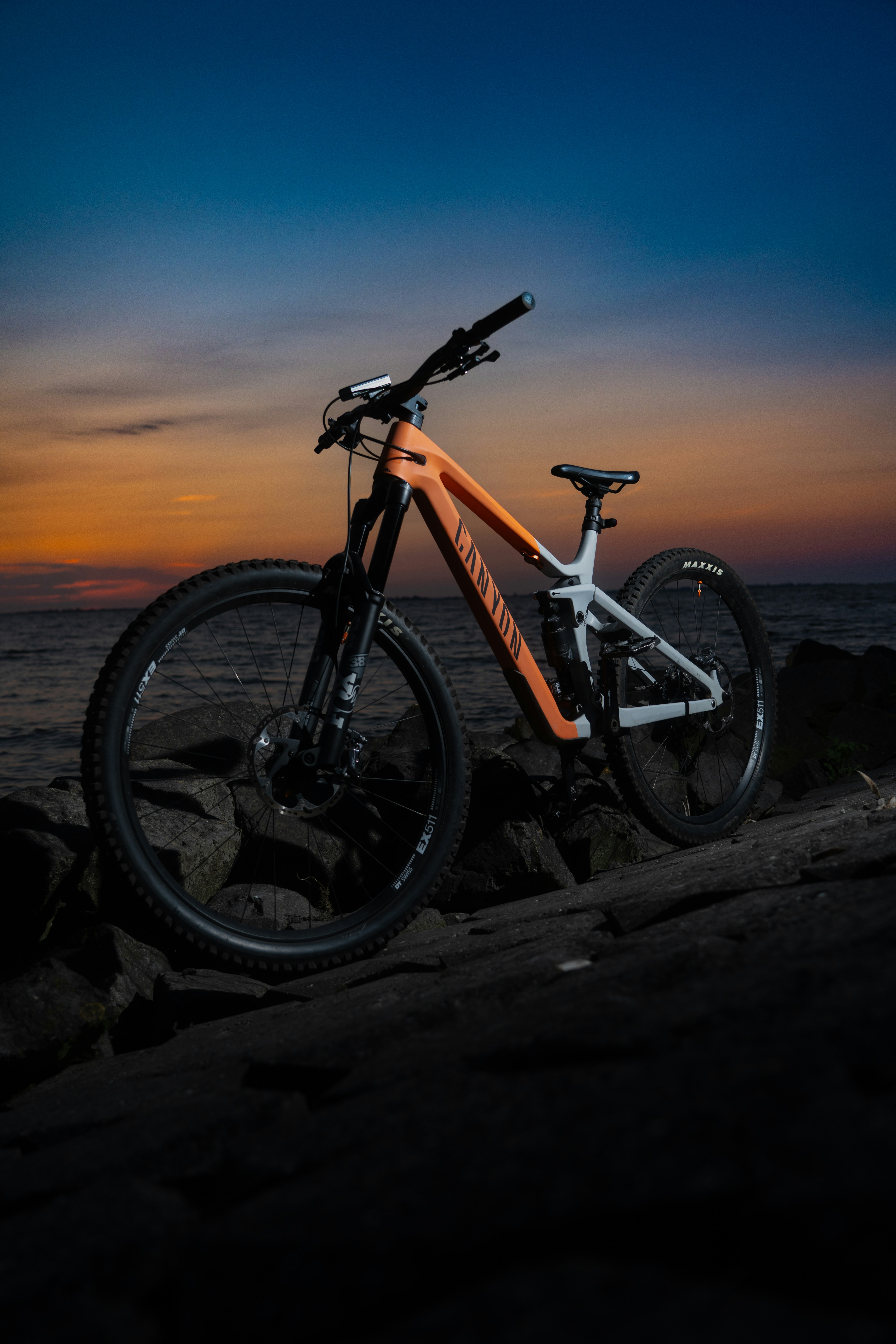 A bike parked on top of a rock near the ocean