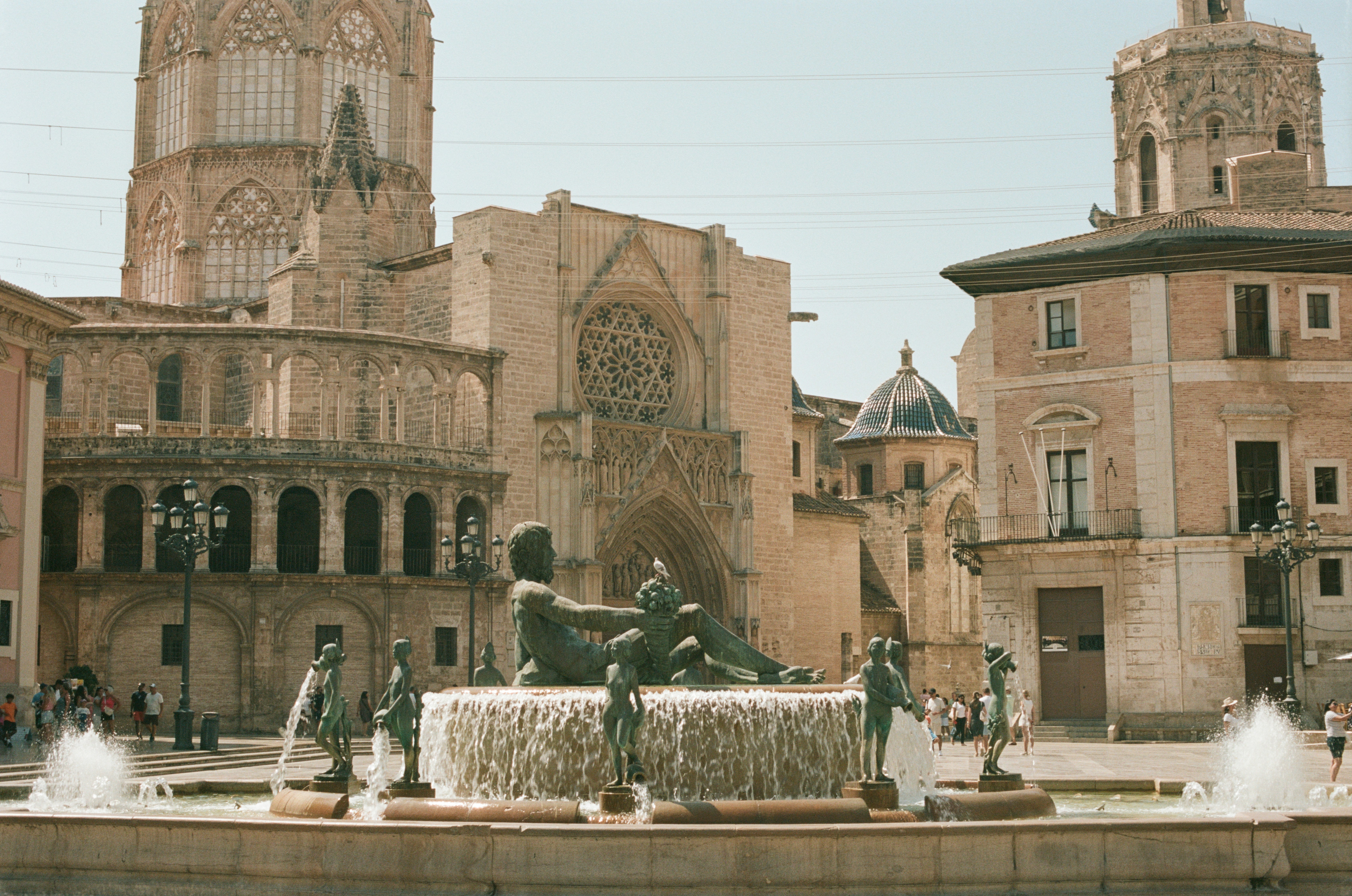 A fountain in front of a building with a clock tower in the background