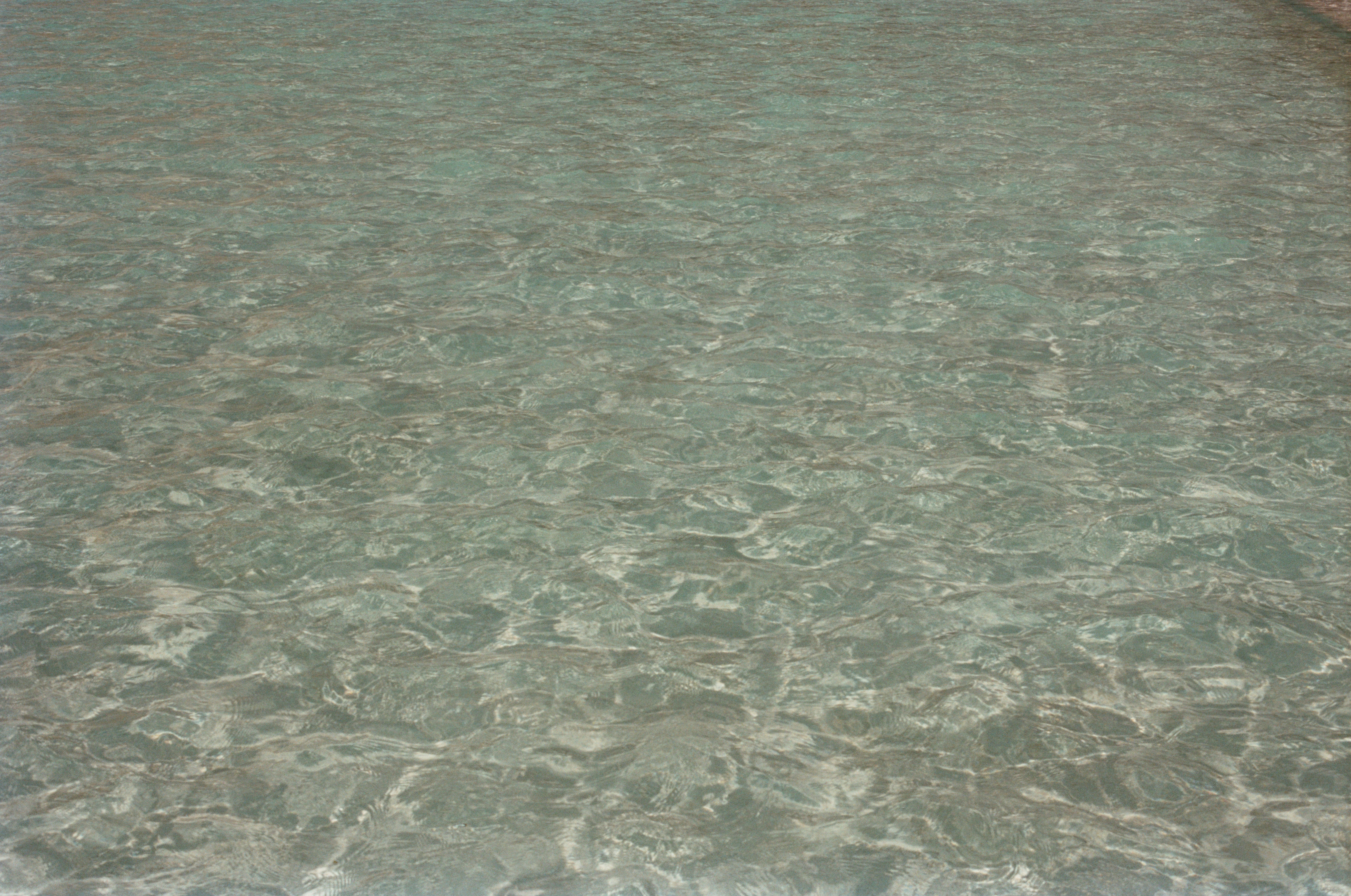 A bed with a white comforter on top of it