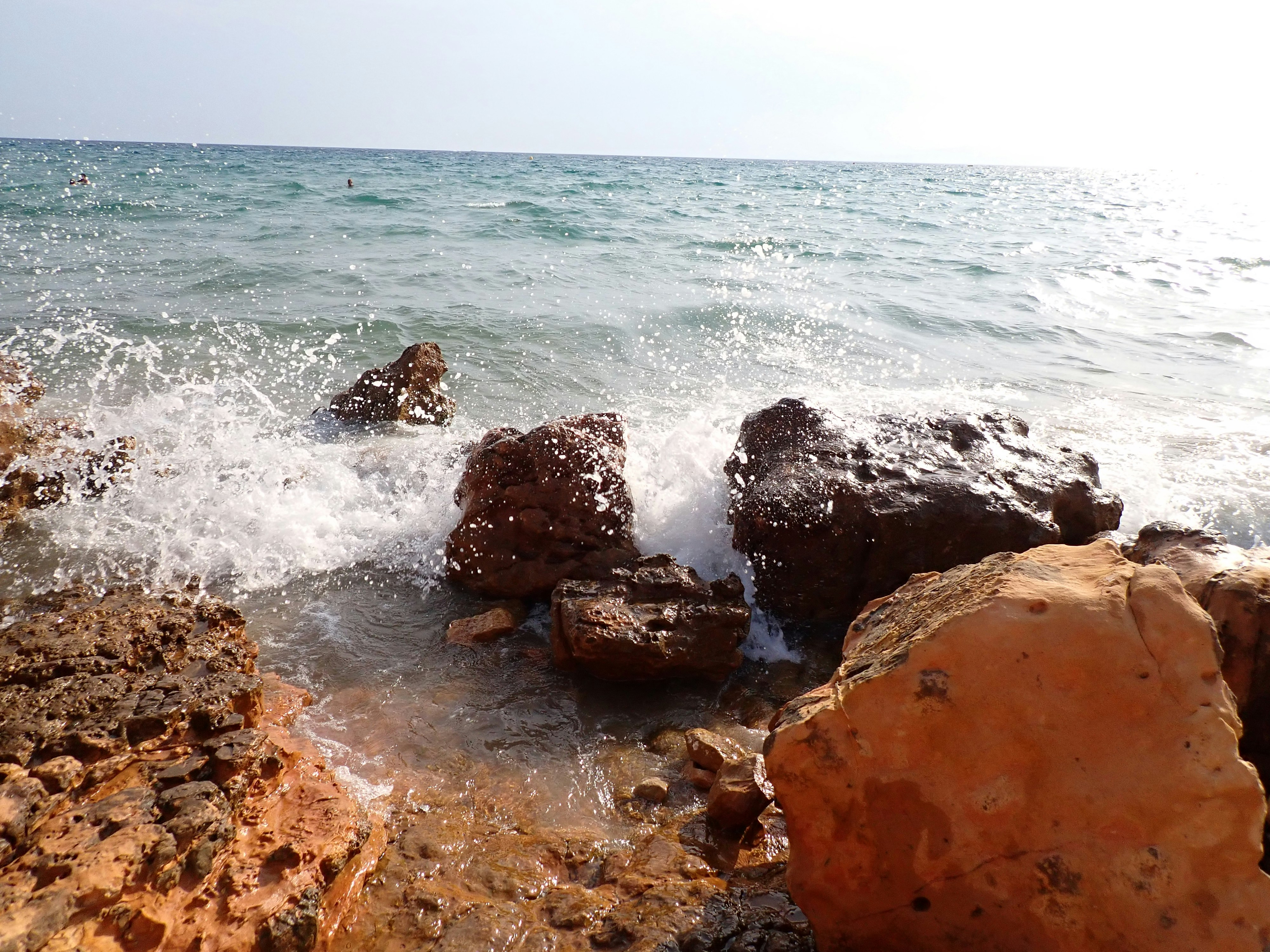 A rocky shore with waves crashing against the rocks