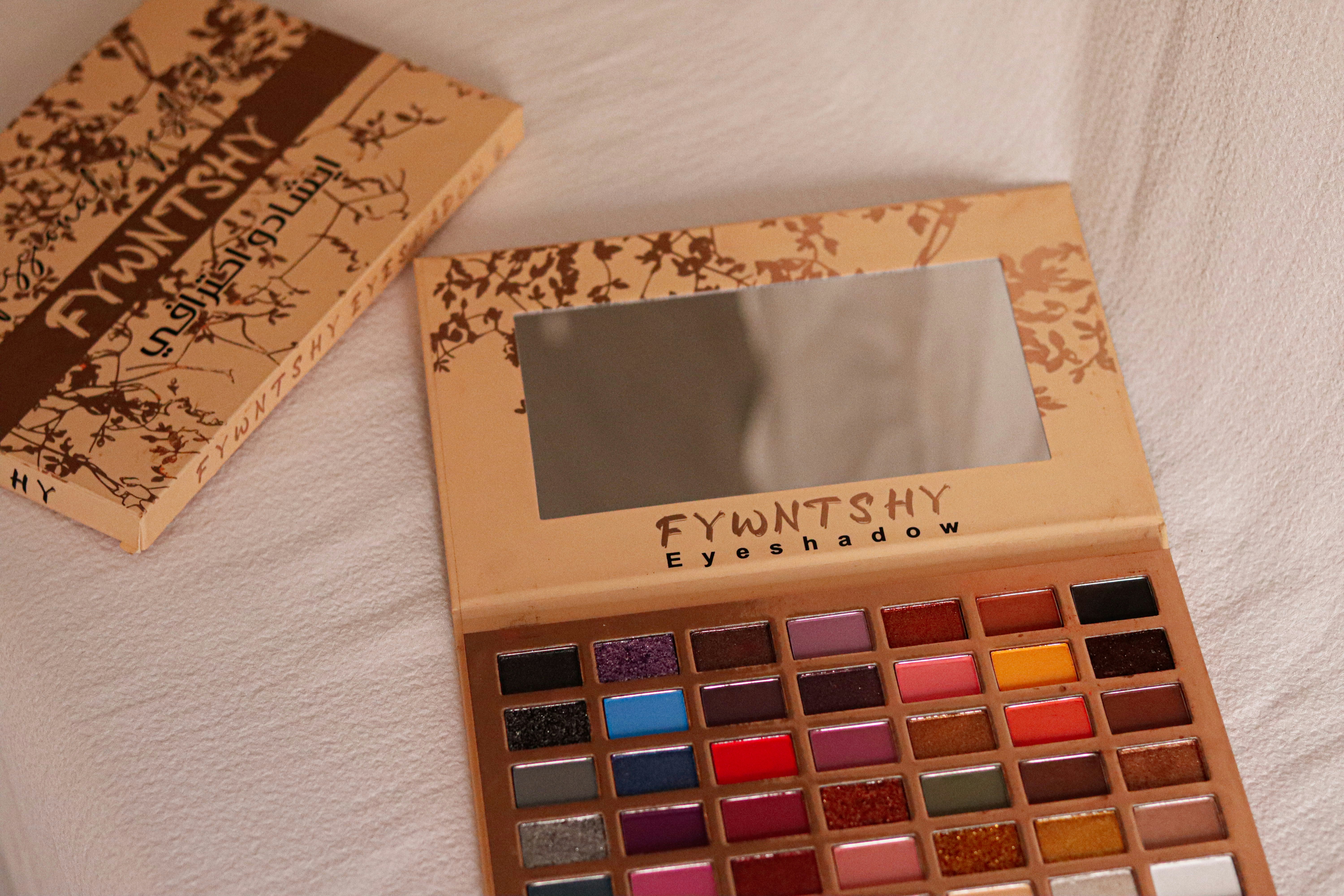 A palette of eyeshades and a book on a bed