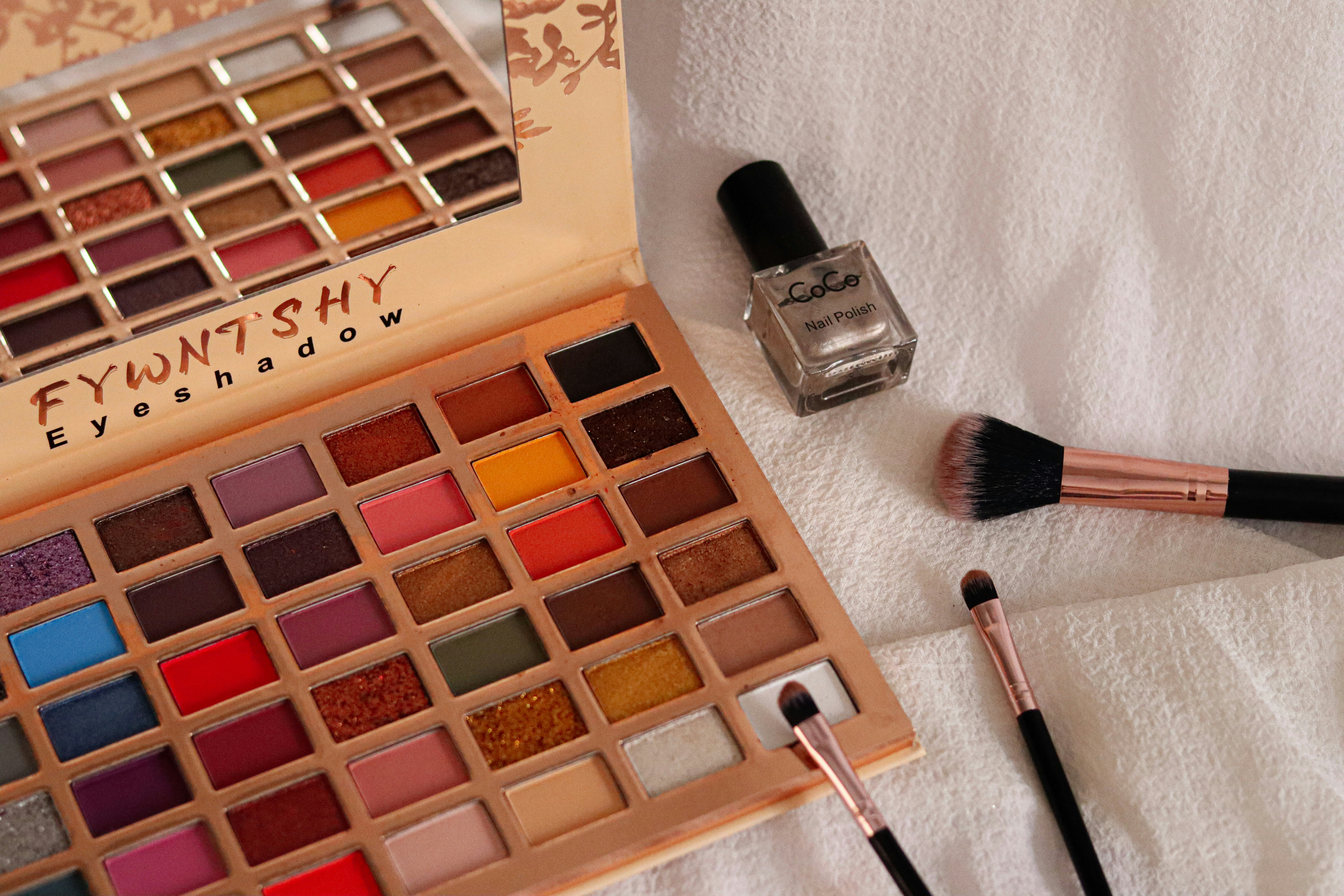 A close up of a makeup set on a bed