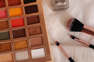 A palette of makeup and a brush on a towel
