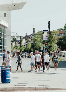 A group of people walking down a street next to a tall building