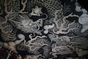 A black and white picture of a dragon on a wall