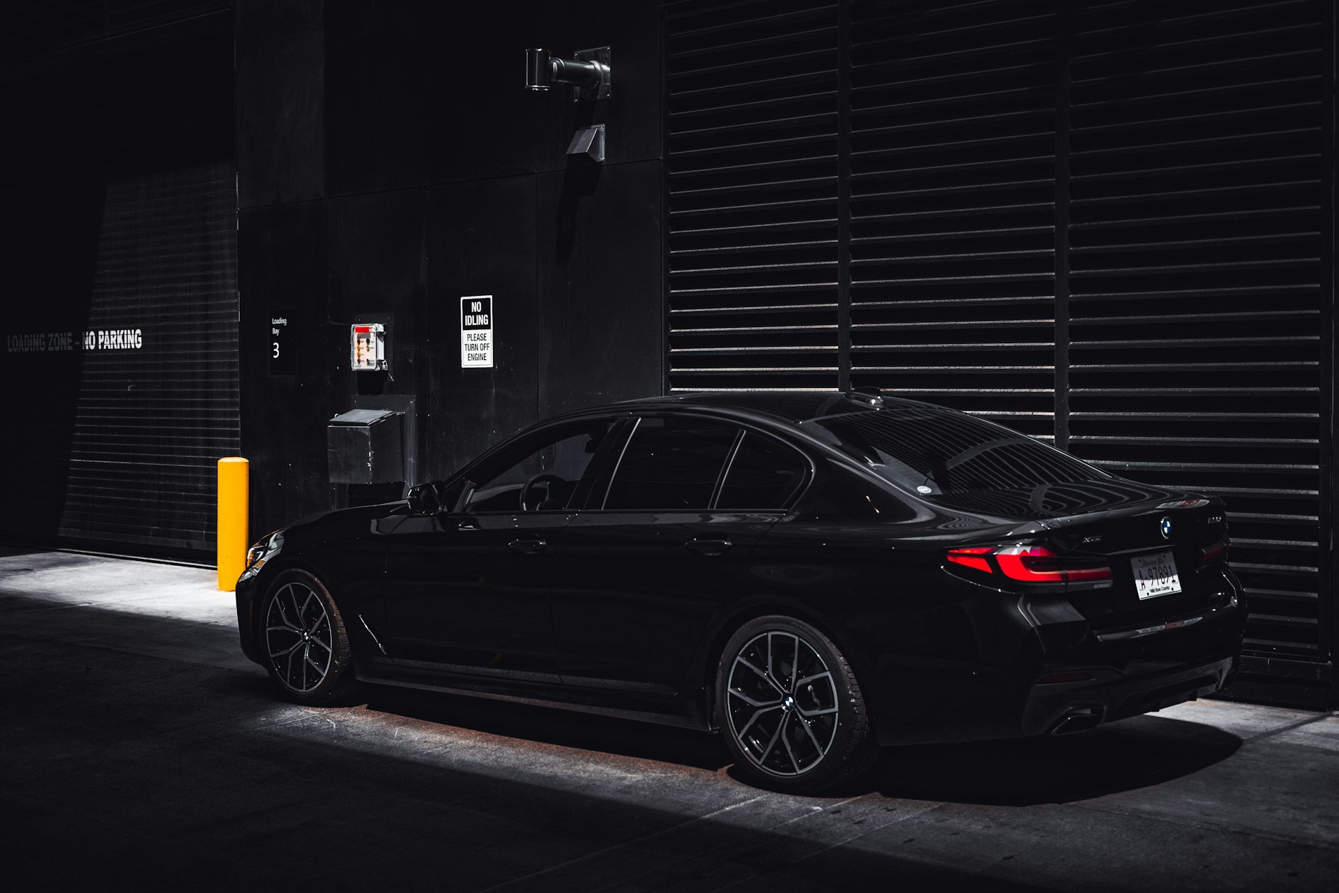 A black car parked in front of a parking meter