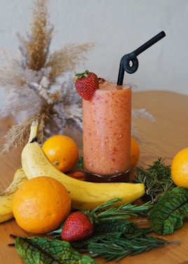 A smoothie with strawberries and oranges on a table