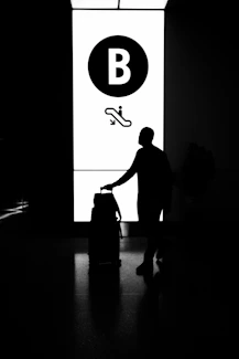 A black and white photo of a person with a suitcase