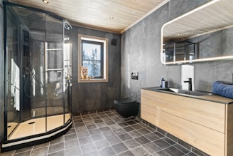 A bathroom with a walk in shower next to a sink