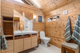 A bathroom with wooden walls and a toilet