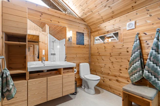 A bathroom with wooden walls and a toilet