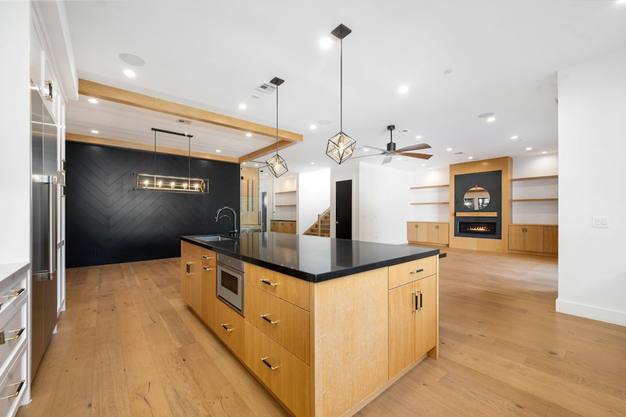 An open kitchen with a timber island, built-in cabinetry and oak floors